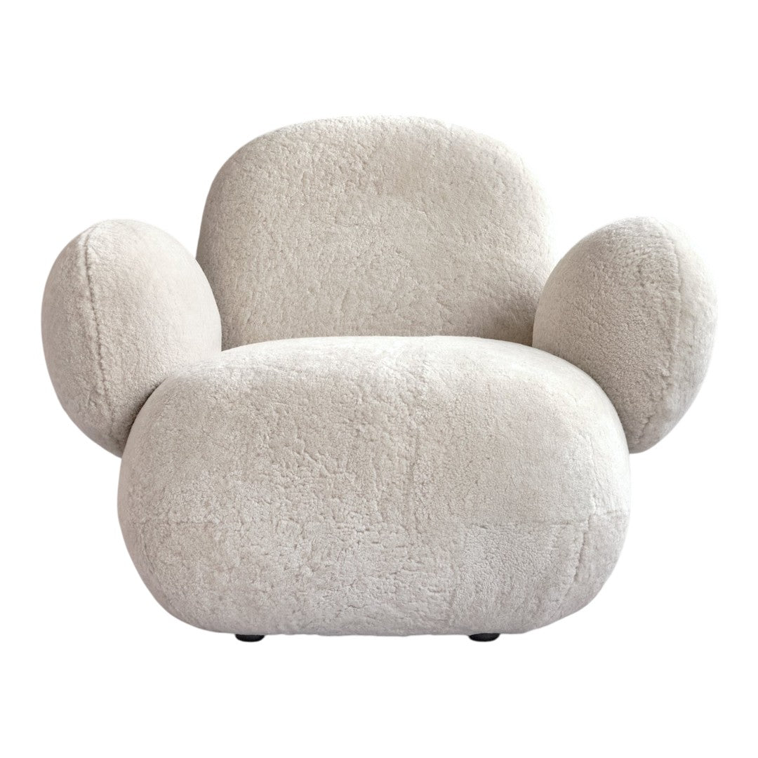 Cozy cream-colored chair with soft, textured fabric and rounded shapes for a modern, stylish look.