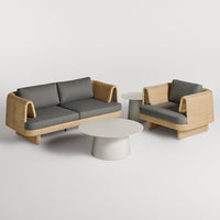 Stylish outdoor furniture set featuring grey cushions and natural rattan weave against a minimalist white table.