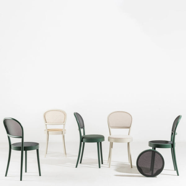 Colorful chairs in green, cream, and black with mesh detailing on a white background, showcasing modern design.