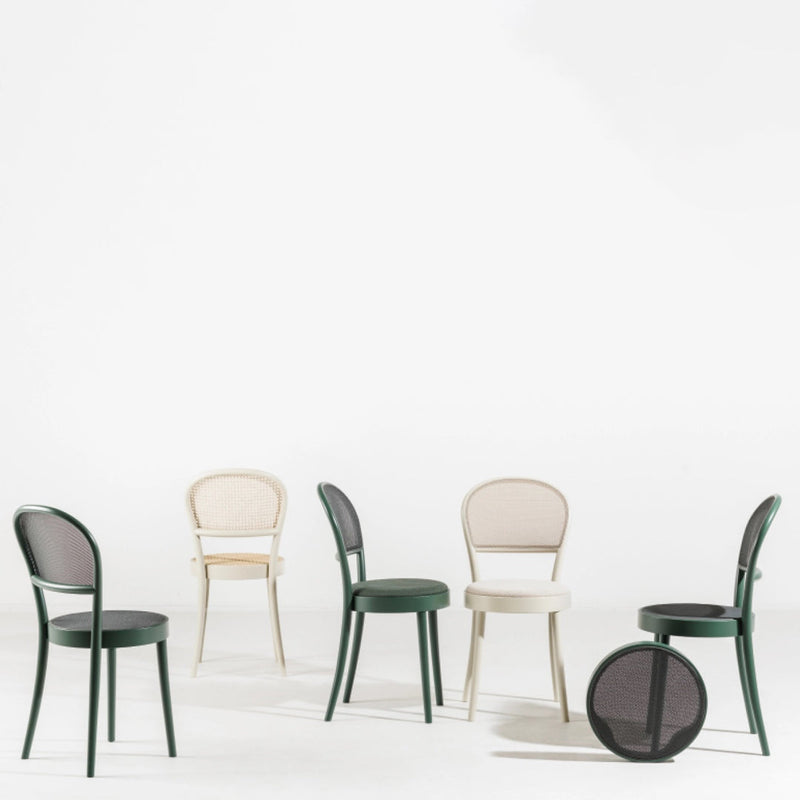 Colorful chairs in green, cream, and black with mesh detailing on a white background, showcasing modern design.