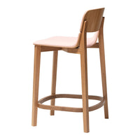 Light pink stool with natural wood legs and a minimalist design, showcasing a modern and stylish aesthetic.