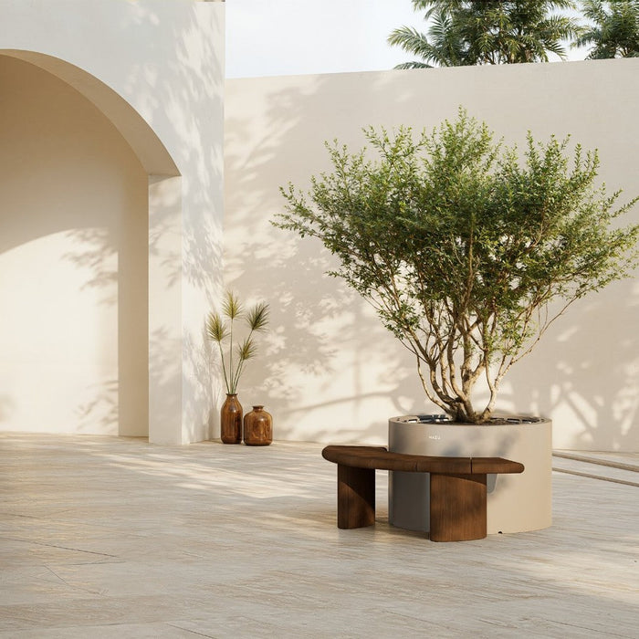 "Modern wooden bench in earthy tones with a minimalist landscape featuring neutral walls and green foliage."