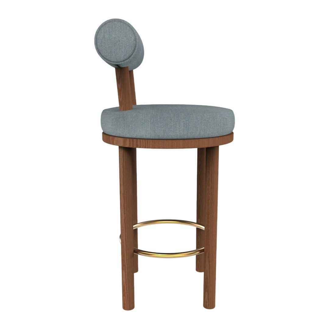 Light blue upholstered stool with a round backrest, complemented by a warm wood frame and gold footrest.