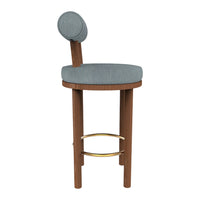 Light blue upholstered stool with a round backrest, complemented by a warm wood frame and gold footrest.