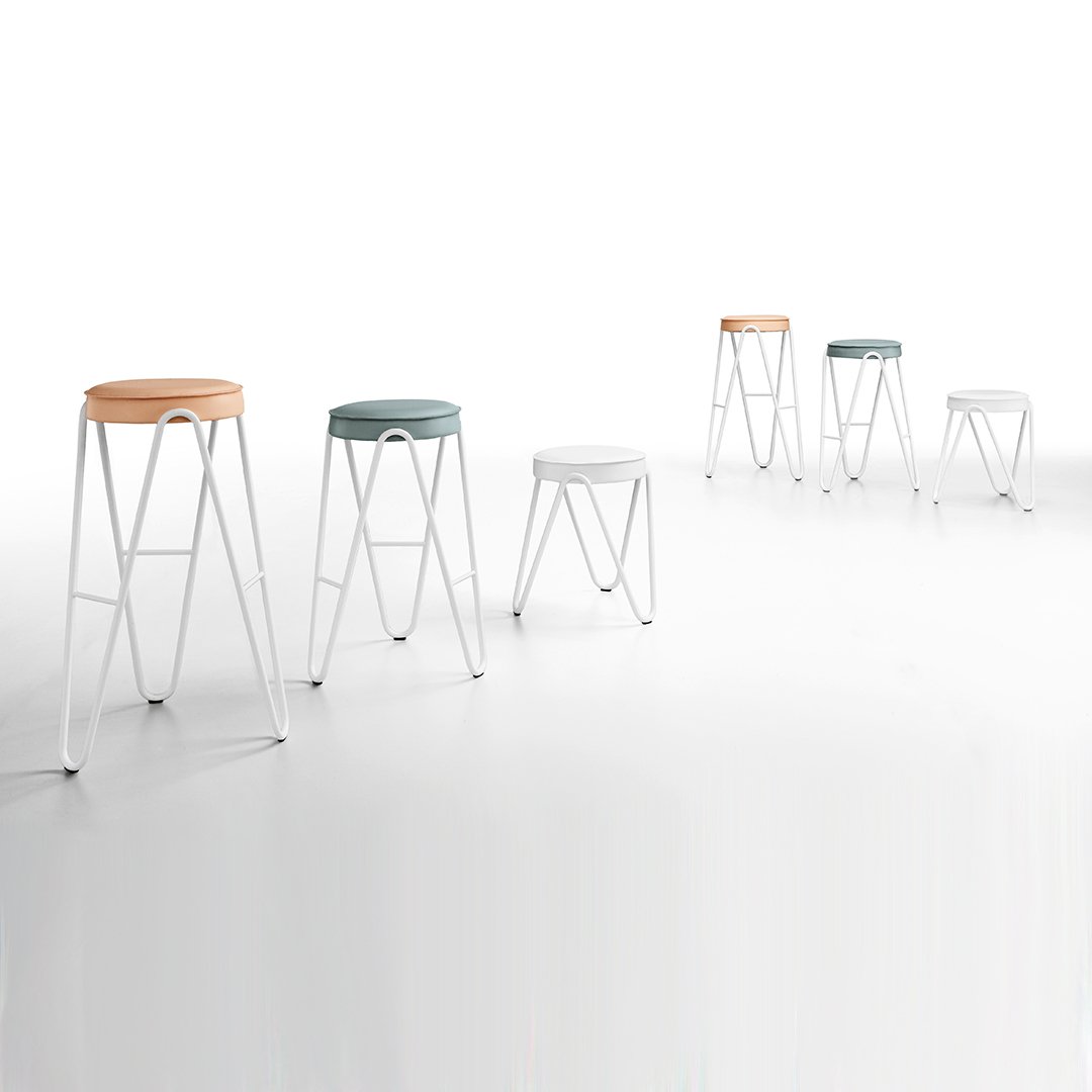 Colorful modern stools in white, mint green, and light orange with sleek white metal frames.