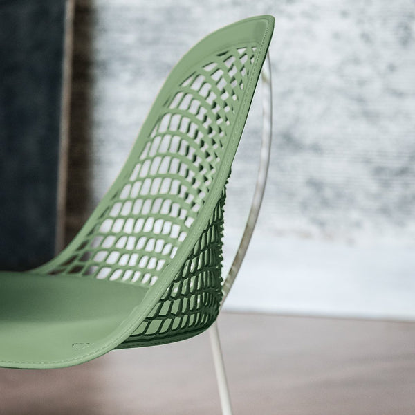 Modern green chair with a unique mesh pattern and sleek transparent legs, perfect for contemporary decor.