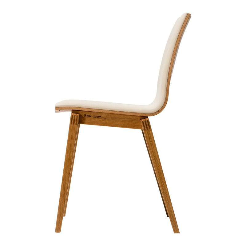 Minimalist chair with a creamy white seat and natural wood legs, showcasing a sleek, modern design.