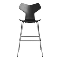 Black modern bar stool with curved backrest and sleek chrome legs. Minimalist design emphasizes clean lines and patterns.