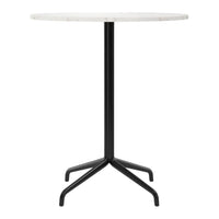Round marble tabletop in white with a sleek black metal base, featuring a minimalist design. Perfect for modern decor.