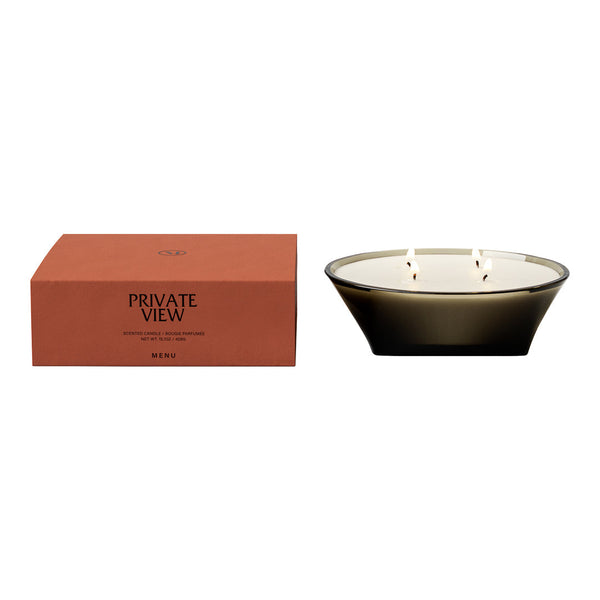 Sleek black and white candle in a modern bowl with a rust-colored box featuring elegant typography.