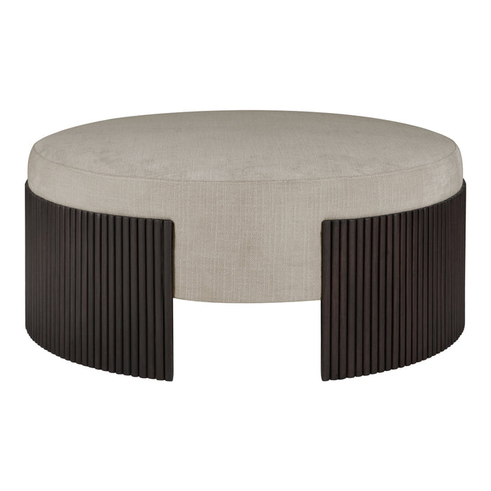 Round beige upholstered ottoman with vertical dark wood accents, featuring a modern, minimalist design.