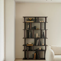Dark wood bookshelf with geometric patterns, accented by black and gold decor against a soft beige wall.