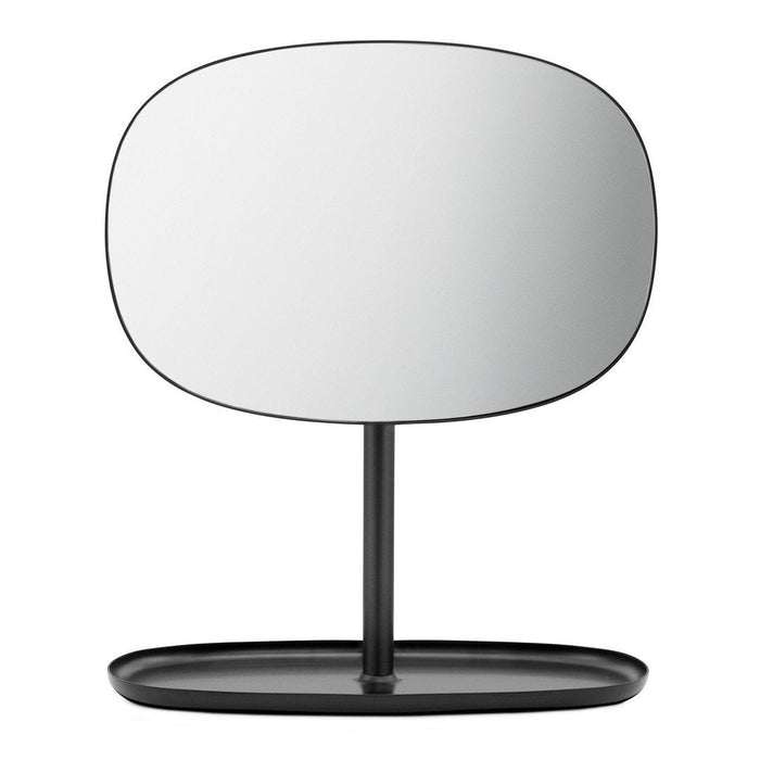 Minimalist black table mirror with an oval shape and smooth reflective surface, set on a sleek, round base.