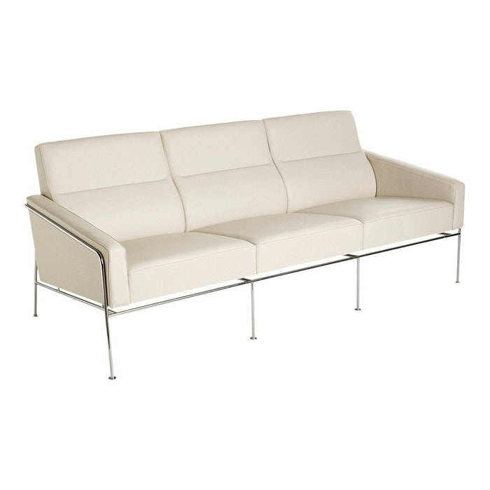 Minimalist white sofa with sleek design, featuring smooth upholstery and chrome legs for a modern aesthetic.