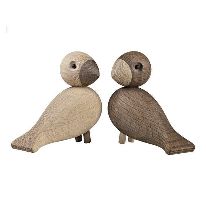 "Wooden bird figurines in light and dark tones with smooth textures and rounded shapes."