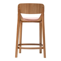 Natural wood bar stool with a soft pink seat cushion and a minimalist design, highlighting warm tones and simplicity.