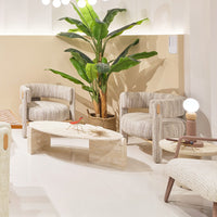 Textured beige and cream chairs with striped patterns, light wooden table, and vibrant green plant in a bright, airy space.