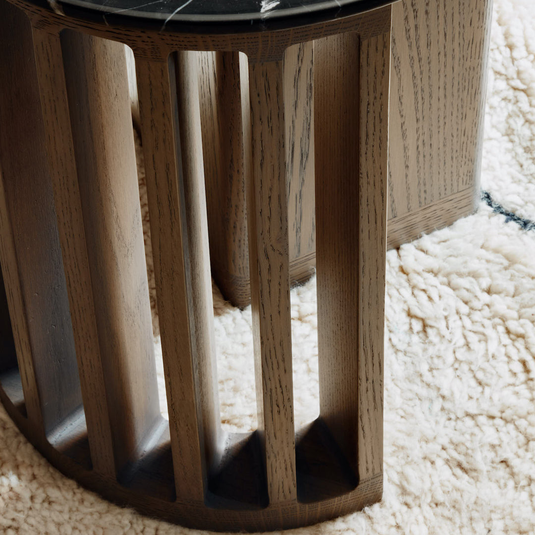 Wooden furniture with a natural oak finish, featuring a geometric design and contrasting black marble top.