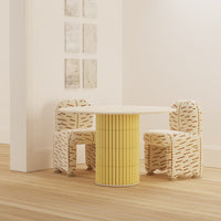Yellow striped table with patterned beige chairs featuring subtle orange accents, set in a minimalist space.