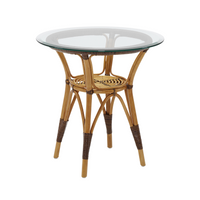 Round rattan side table with natural bamboo finish and clear glass top, featuring woven textures and earthy tones.