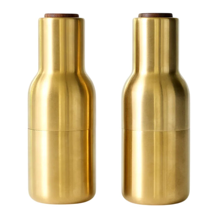 Brushed gold pepper mills with a sleek, modern design and smooth, shiny finish. Elegant wooden tops add contrast.