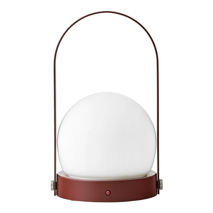 Modern lamp with a round white glass shade and a sleek rust-colored base and handle. Minimalist design for any decor.
