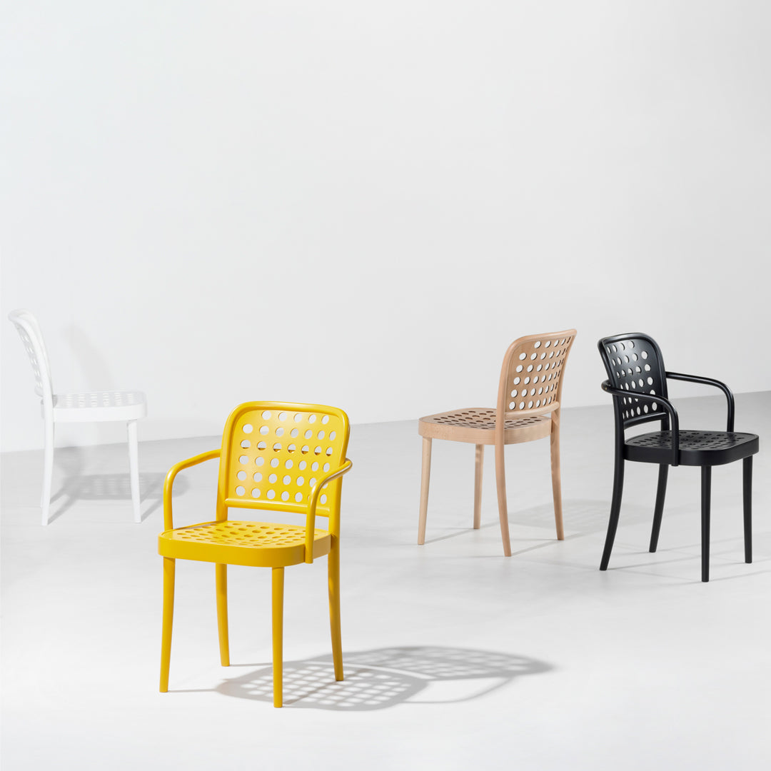 Colorful chairs in yellow, beige, black, and white with elegant open patterns, perfect for modern decor.