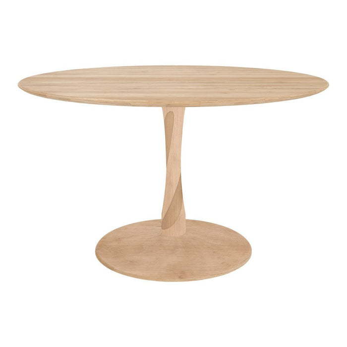Light oak round dining table with a sleek, smooth finish and a unique sculptural base, creating a modern aesthetic.
