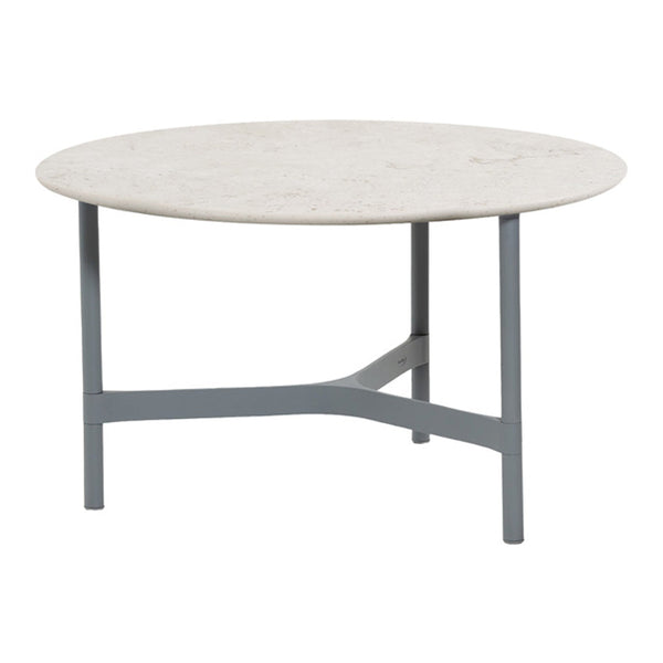 Round coffee table with a smooth, light beige top and a sleek gray metal base.