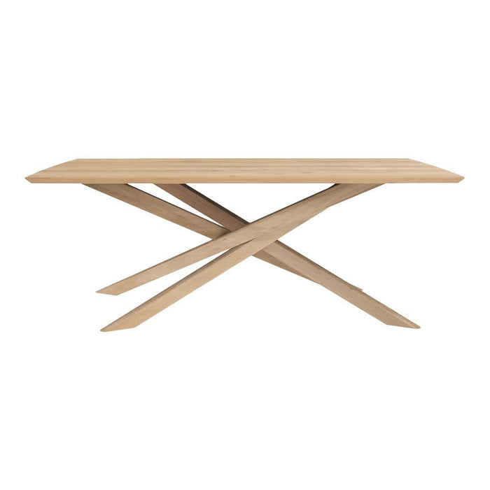 Natural wood dining table with a minimalist design, featuring a light oak color and angular, crisscross base pattern.