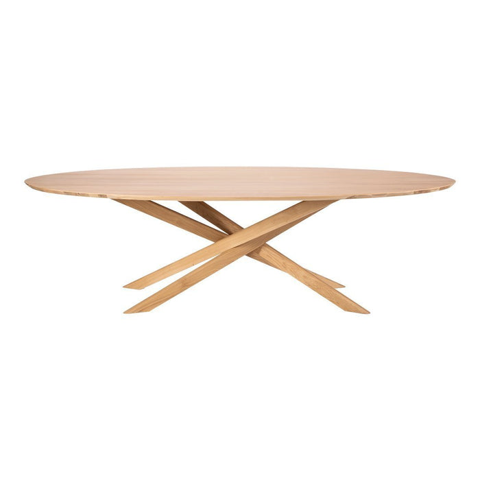 Natural wood oval table with a light beige surface and crisscrossed light brown legs. Modern and elegant design.
