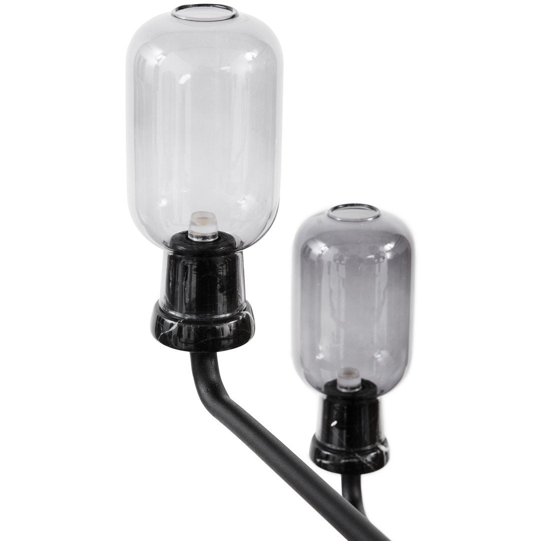 Clear glass lamps with black fittings on a curved black frame, featuring a sleek and modern design.