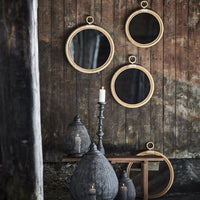 "Set of four round mirrors with wooden frames, featuring a rustic wood backdrop and black decorative accents."