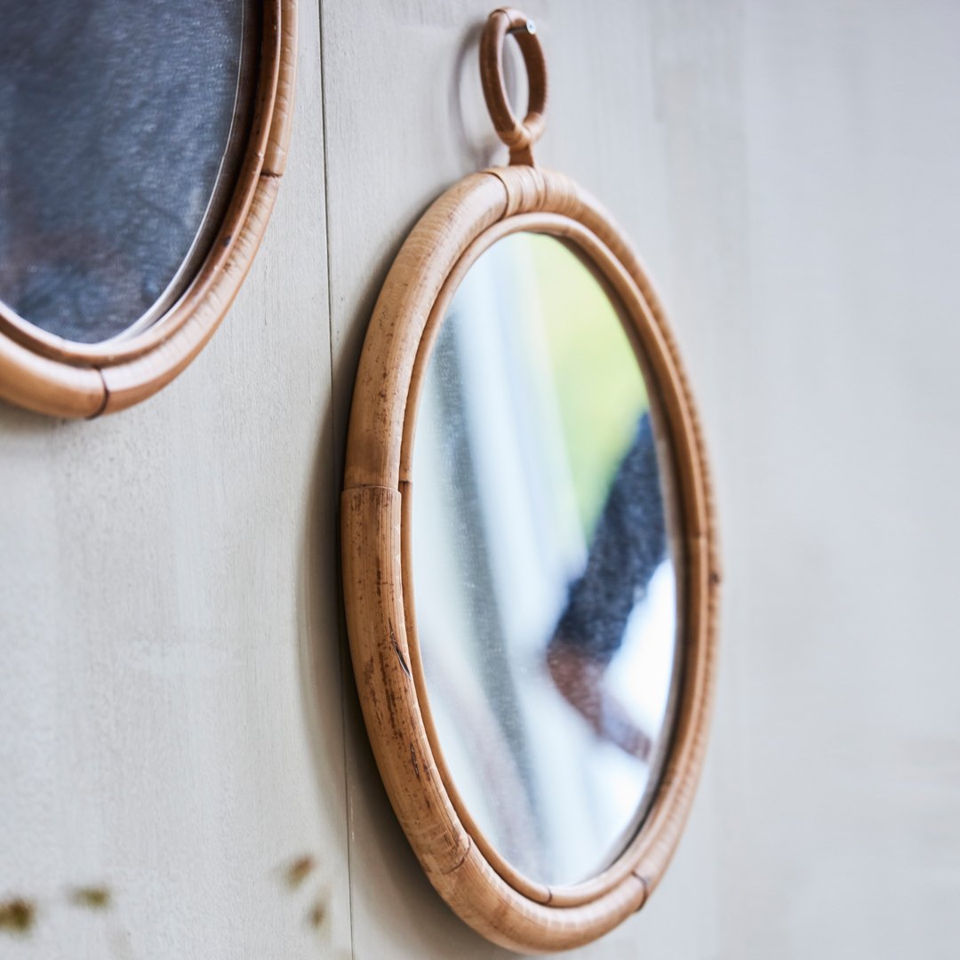"Natural bamboo oval mirror with a smooth, reflective surface and a warm tan frame, perfect for rustic decor."