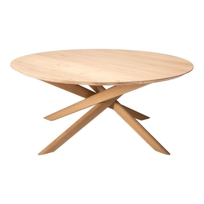 Natural wood round table with smooth surface and stylish angled legs in a light beige finish.
