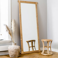 "Natural bamboo frame mirror with a minimalist design against a light gray wall, featuring earthy tones and soft textures."