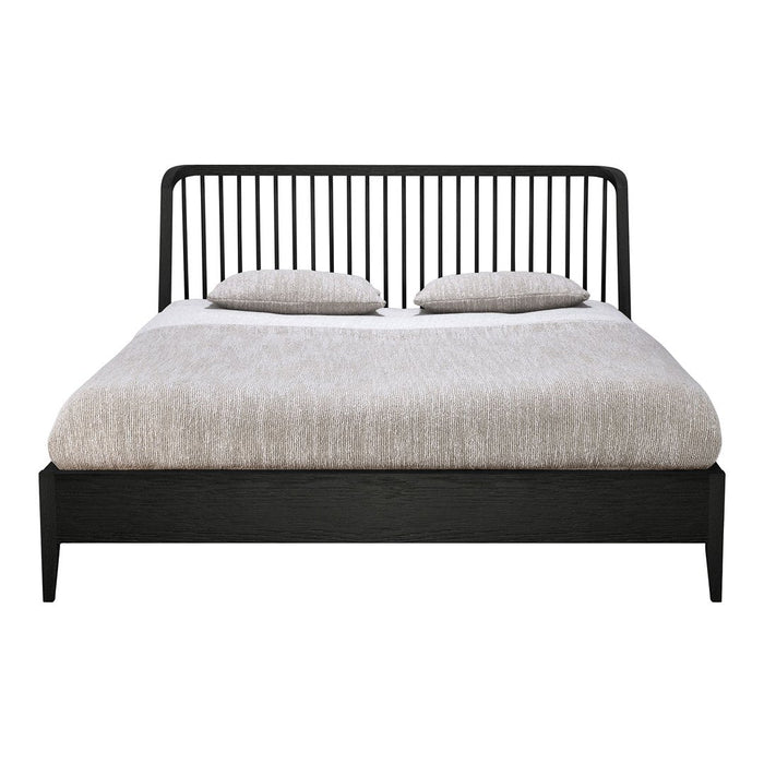 Black wooden bed frame with a slatted headboard and two light gray pillows on a soft beige comforter.