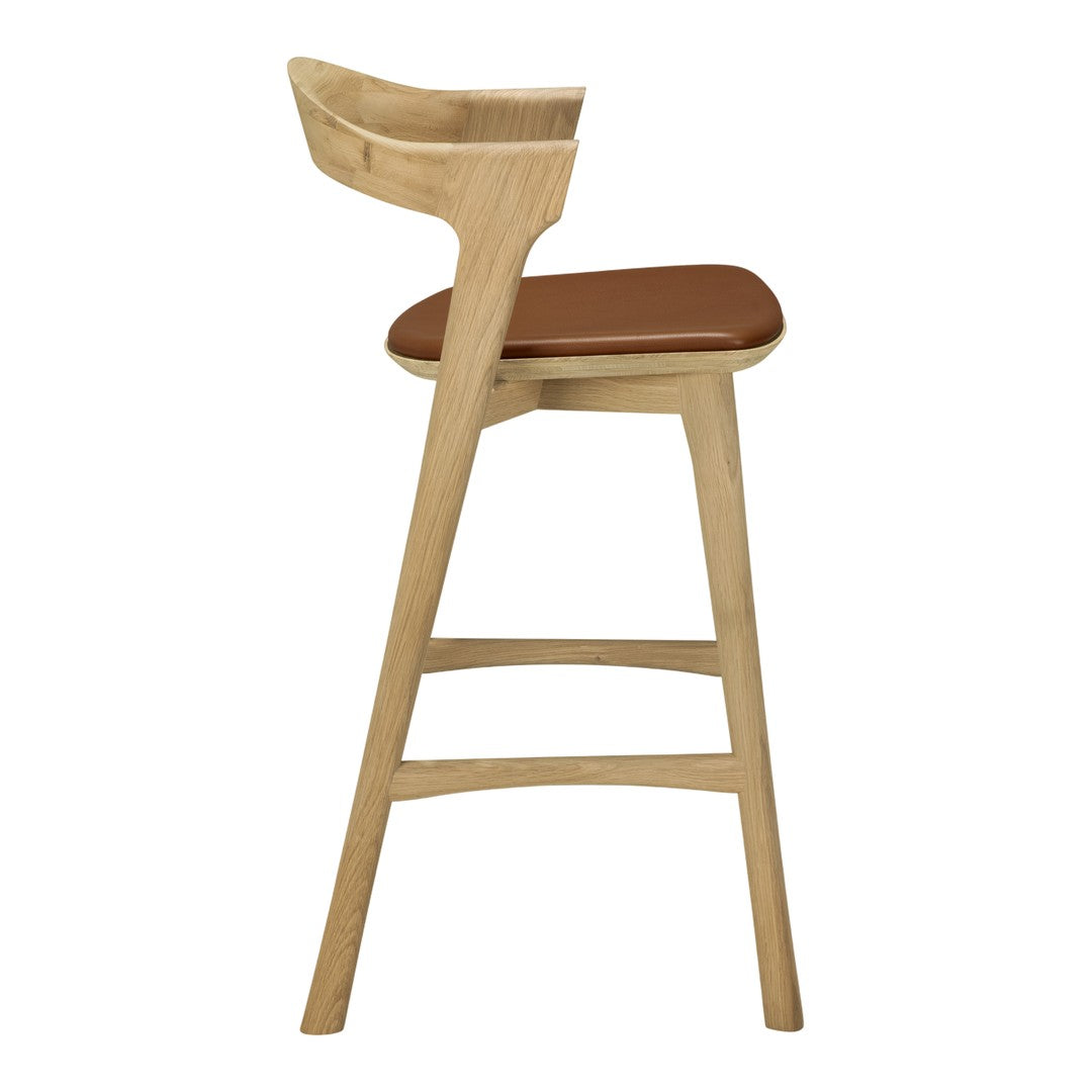 Wooden bar stool with a light oak finish and brown leather seat, showcasing a modern, minimalist design.