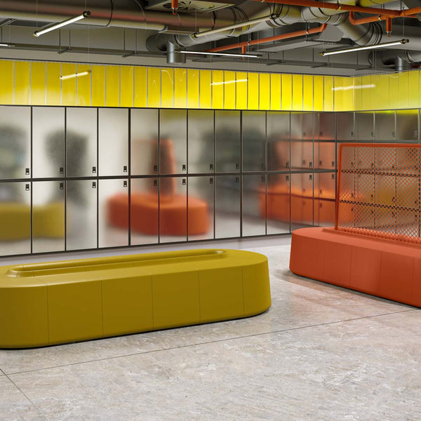 Vibrant yellow, bold orange, and earthy green seating in a modern locker room setting.