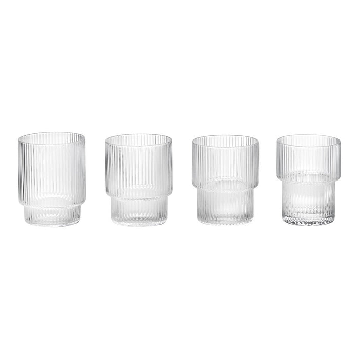 Set of four clear glass tumblers featuring vertical ribbed texture and varying heights. Perfect for modern table settings.