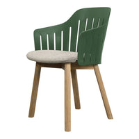 Green slatted chair with a light beige cushion and natural wood legs. Modern design for stylish interiors.