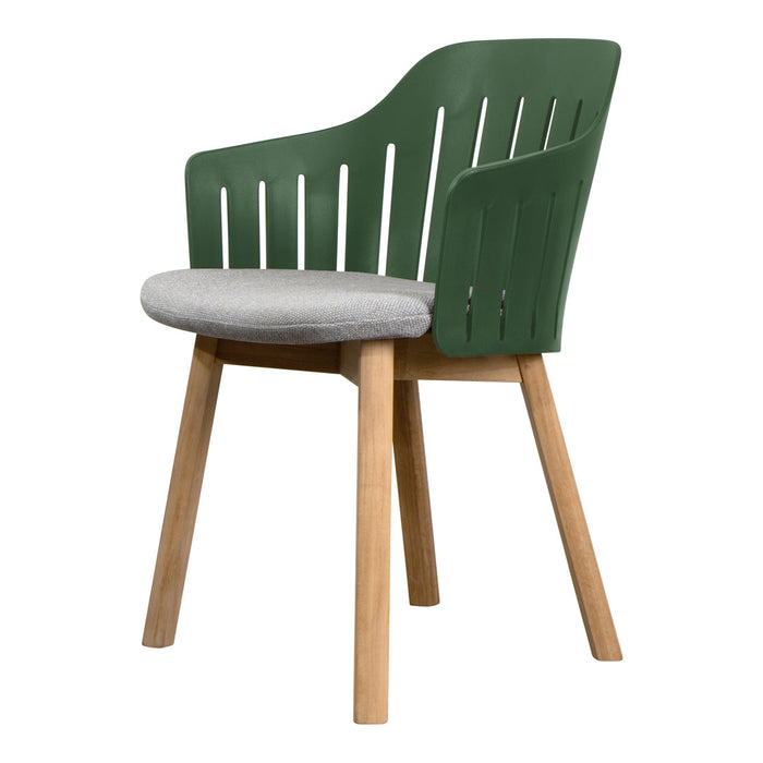 Green chair with slatted backrest and grey cushion, supported by wooden legs. Modern, minimalist design.