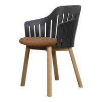 Black slatted chair with a brown upholstered seat and natural wood legs, combining modern and rustic elements.