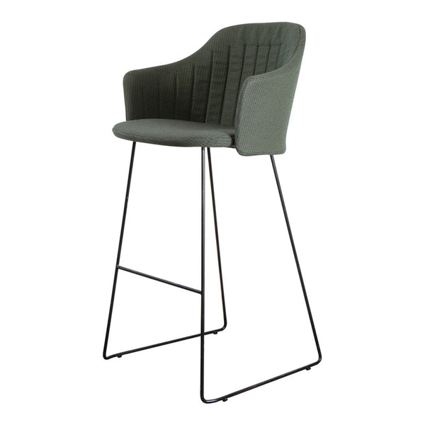 Green padded bar stool with stitched detailing and sleek black metal legs. Modern design for contemporary spaces.