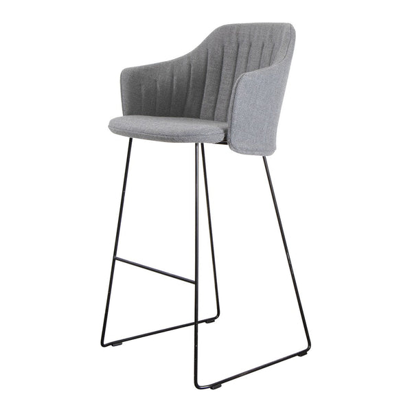 Gray upholstered barstool with vertical ribbed pattern and sleek black metal legs.