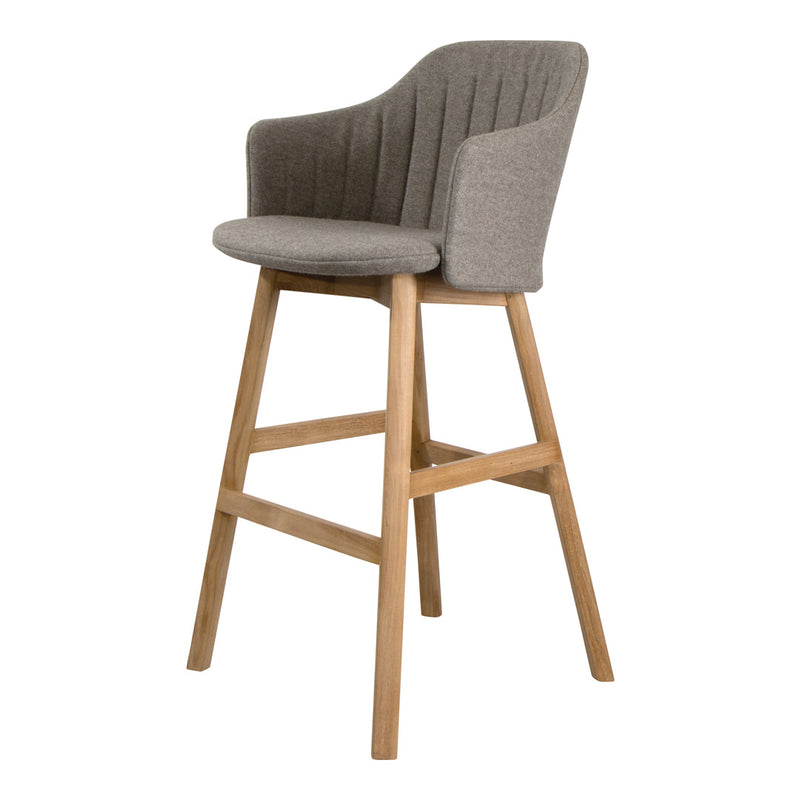 Gray upholstered bar stool with ribbed pattern and natural wood legs. Stylish and modern design for any space.