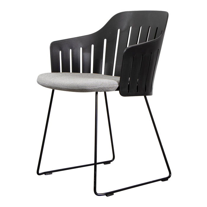 Modern black chair with slatted backrest and light gray cushioned seat, featuring sleek black metal legs.