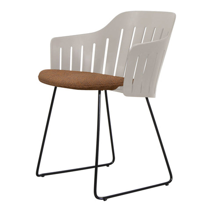 White chair with slatted design and brown cushioned seat on a black metal frame. Modern and minimalist style.