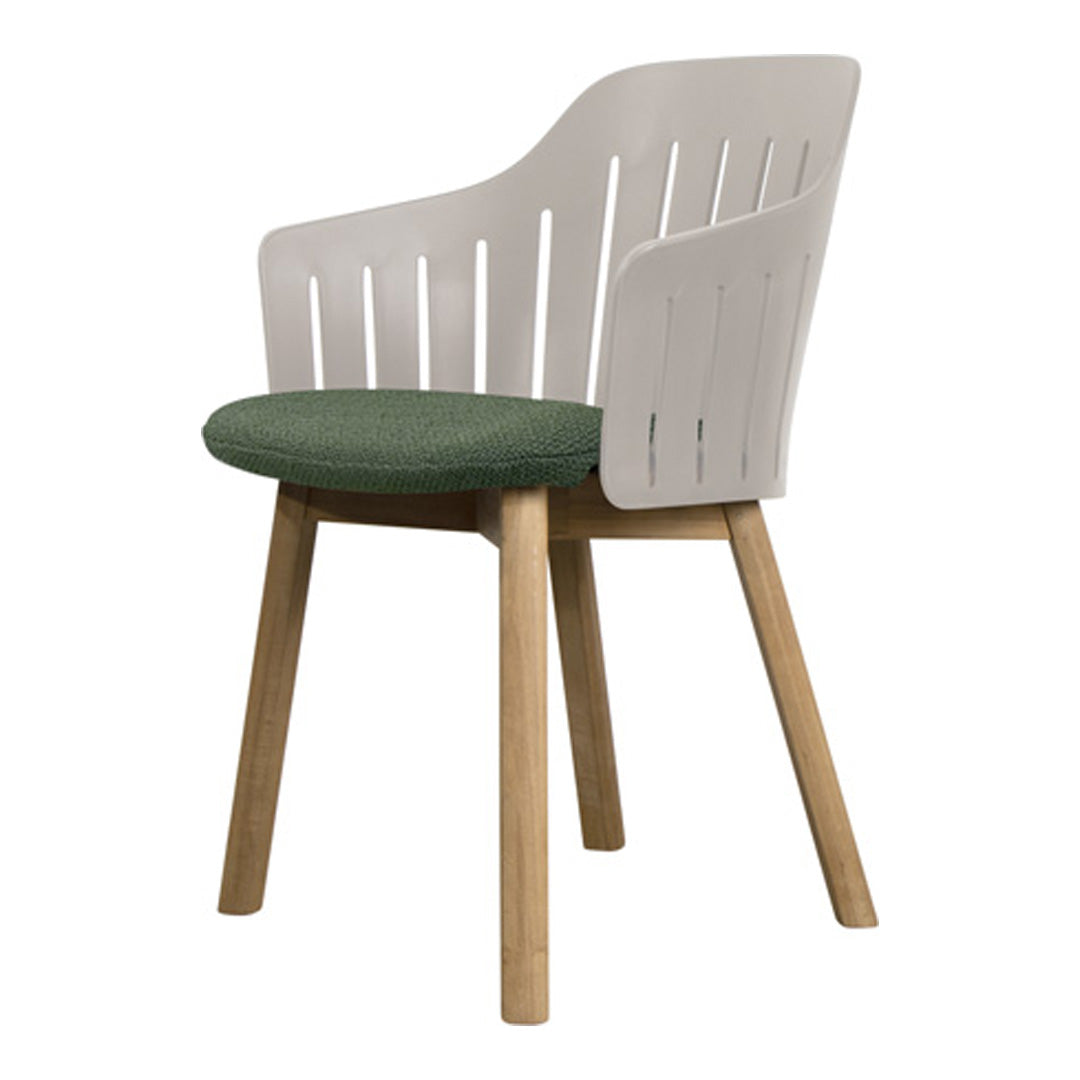 White chair with green upholstered seat and natural wood legs, featuring a modern slatted back design.