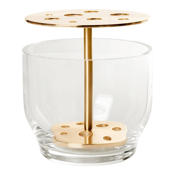 Clear glass tumbler with a metallic gold holder featuring circular cutouts on top and a base design.
